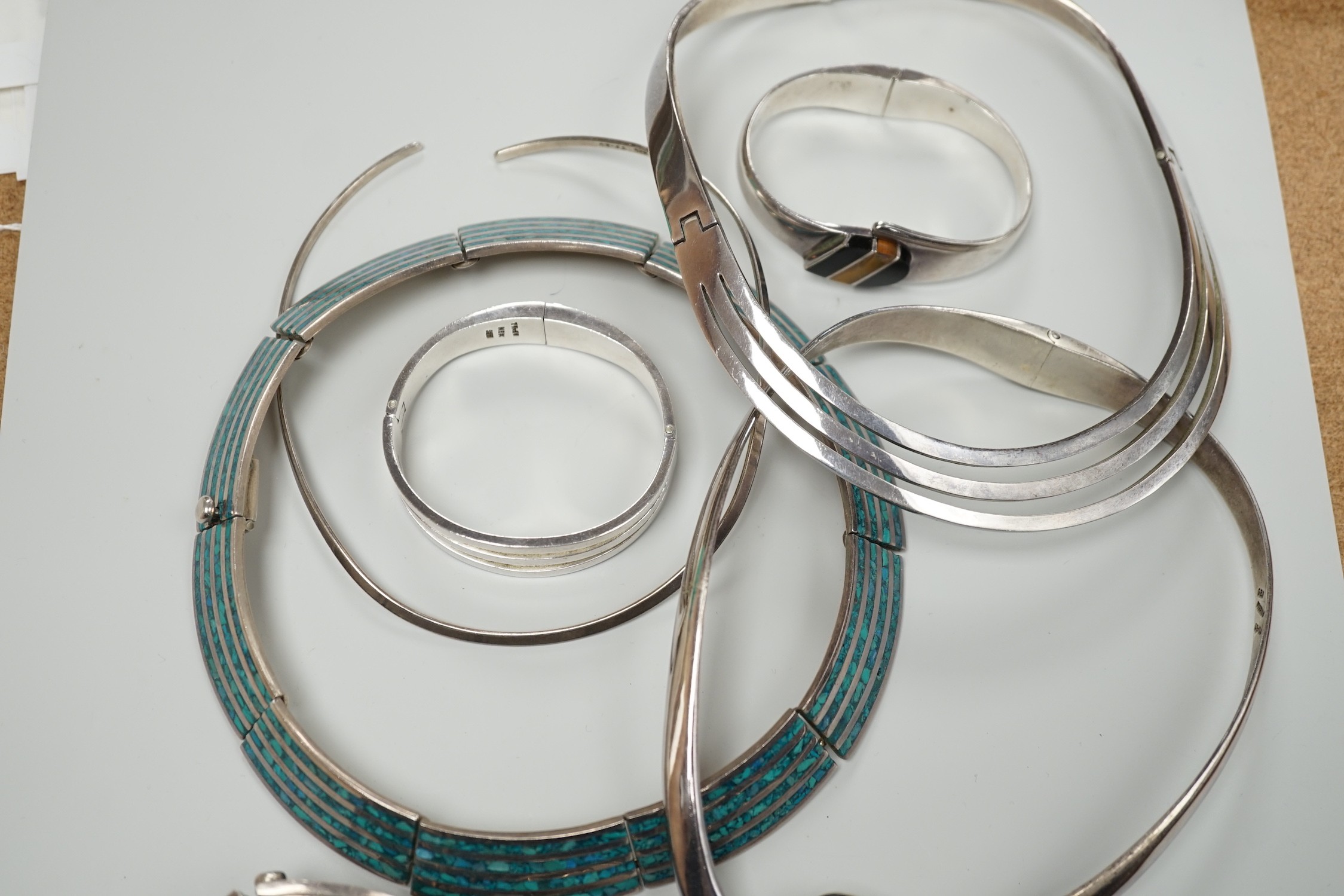 A Mexican 925 hinged necklet, 15.8cm (top to bottom) and matching bracelet, a similar suite of 925 and turquoise and enamel? jewellery, comprising a necklet, bracelet and pair of ear clips, a similar 925, black onyx and